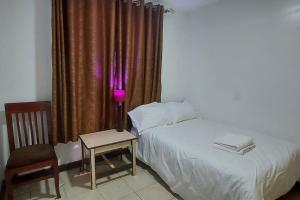 阿西里弗2 bedroom Apt 20 min to JKIA Airport,SGR Train St.的一间卧室配有一张床和一张带台灯的桌子