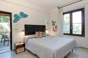 马利亚诺因托斯卡纳Artemisia negli ulivi b&b的卧室配有一张床上的蝴蝶壁床。