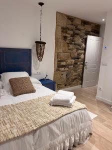 卢戈Caraxolas的一间卧室设有一张大床和石墙