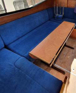 BazollesMagnifique bateau au coeur du Nivernais à l'étang de BAYE的一张蓝色的沙发,上面有一张桌子