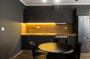 亚历山德鲁波利斯Stamatina's Luxury Apartments (Central 3rd floor)的厨房配有桌子和一些黑色橱柜