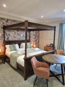 惠特比雷索鲁森酒店的一间卧室配有一张天蓬床和一张桌子