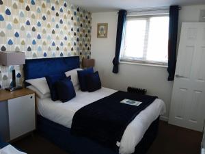 布莱克浦法尔德国际旅馆的一间卧室配有一张带蓝色枕头的大床