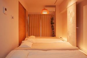 名古屋HISASHI 池下的带窗户的客房内的两张床