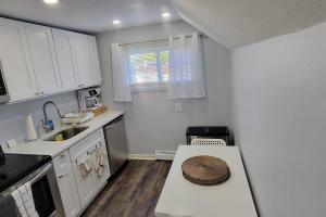 尤宁戴尔Cheerful 2-Bedroom Apartment with Smart Home Tech.的厨房配有白色橱柜和一张带帽子的桌子
