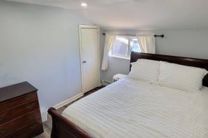 尤宁戴尔Cheerful 2-Bedroom Apartment with Smart Home Tech.的一间卧室配有一张床、一个梳妆台和一扇窗户。