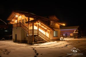 沃罗赫塔Apartments Chalet Girska Hatyna的夜晚雪中的房子