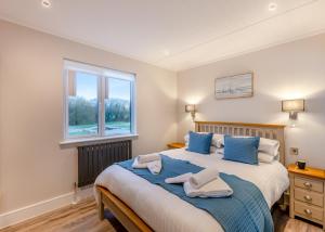波尔顿乐法尔德Hambleton Lakeside Lodges的一间卧室配有一张带蓝色枕头的大床