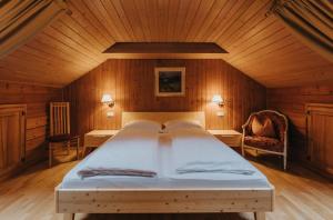 万多耶斯Residence Obermoarhof - comfortable apartments for families, swimmingpool, playing-grounds, Almencard的木制客房内的一间卧室配有一张大床