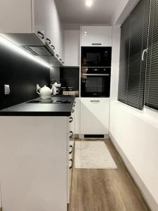 鲁塞Asitad DeLuxe Apartments的厨房配有白色和黑色的柜台和电器