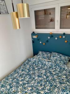 蒙贝利亚尔Appartement avec terrasse et parking gratuit accolé的一间卧室配有一张蓝色床头板的床