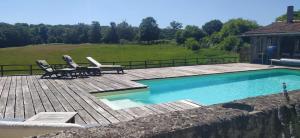 FromentalChâteau de Montautre的一个带两把椅子的庭院和一个游泳池