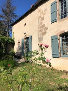 FromentalChâteau de Montautre的院子里有绿色百叶窗和鲜花的房子