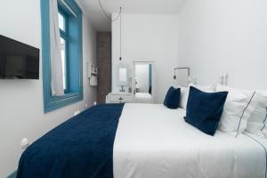 阿马兰特Des Arts的一间卧室配有一张带蓝白色枕头的大床