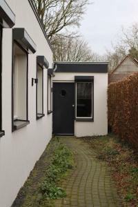 希尔瓦伦比克B & B De Rode Beuk的一座有黑色门和走道的房子