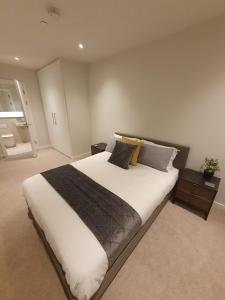 曼彻斯特Lovely 2Bedroom Apartment的卧室配有一张带白色床单和枕头的大床。
