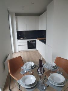 曼彻斯特Lovely 2Bedroom Apartment的厨房配有带盘子和酒杯的桌子