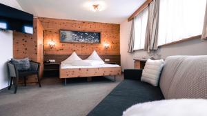 伊施格尔阿尔皮纳酒店的一间卧室配有一张床、一张桌子和一张沙发