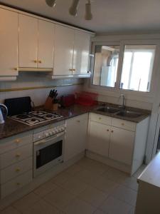 莫莱拉Apartment Kristal Mar的厨房配有白色橱柜和炉灶烤箱。