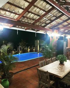 皮雷诺波利斯Magia da Serra Casa Temporada的庭院设有带桌椅的游泳池