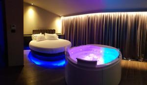 圣安杰洛城Leoni Hotel & Private Spa - LOVE HOTEL的酒店客房带一张床和浴缸