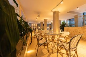 卡塔赫纳Madisson Boutique Hotel Cartagena的一间设有桌椅的餐厅,种植了植物