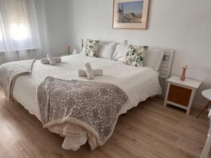孔苏埃格拉Hotel Consuegra的一间卧室设有一张大床,上面有两只填充动物