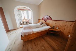 韦尔特湖畔克伦彭多夫索雷奥餐饮酒店的一间卧室设有一张大床,铺有木地板
