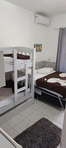 佩尼亚Pousada Casa Amarela Brisa Parque的客房设有两张双层床和一张床。