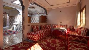伊姆利尔Dar Arghen Family Lodge的客厅配有红色椅子和桌子