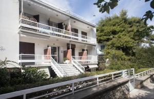 雅典Vouliagmeni Art Micro Loft的白色的房子,设有白色的楼梯和阳台