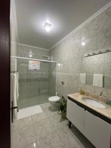 波梅罗迪Recanto Wunderwald Casa Pomerode的带淋浴、卫生间和盥洗盆的浴室