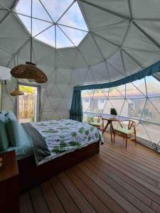 瓜纳卡斯特Ubuntu Glamping的一间卧室,配有带一张床和一张桌子的帐篷