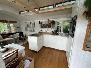 普鲁滕Tiny House Ostsee # Naturwerk的一间带白色橱柜的厨房和一间客厅