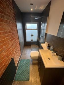 奥萨格Alsager Town Centre Apartment的一间带盥洗盆和砖墙的浴室