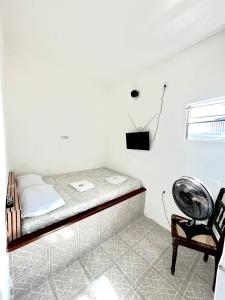 伊塔帕里卡岛维拉克鲁兹Pousada Realce的配有风扇和椅子的客房内的一张床位