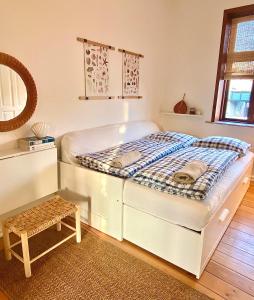 兰讷斯En hel lejlighed i midtbyen - centralt, hyggelig og tæt på alt!的一张白色的床,位于一个带凳子的房间