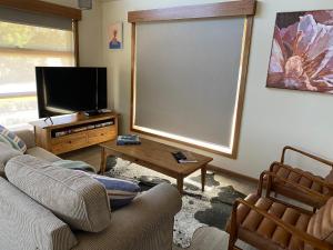 默立基戴森德度假屋的带沙发、电视和桌子的客厅