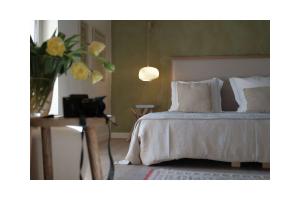 屈屈龙Les Jardins de Sitaara的一间卧室,配有一张床和花瓶