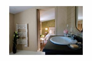 屈屈龙Les Jardins de Sitaara的一间带水槽的浴室和一间带床的房间