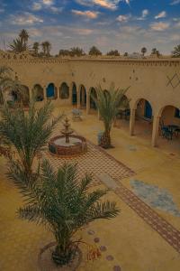 梅尔祖卡奥贝吉诺士酒店的一座带庭院的建筑,庭院内拥有喷泉和棕榈树