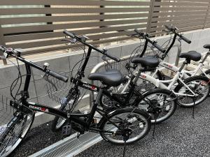 东京KLASSO Tokyo Sumiyoshi Apartments的停在长凳旁边的一群自行车