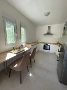 尤塔哈Adriatic Family House的厨房配有桌椅和冰箱。