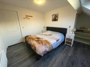巴勒哈姆斯泰德Het Tinkerparadijs, paarden, rust en ruimte.的一间卧室设有一张大床,铺有木地板