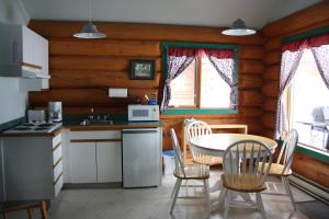 维勒蒙特双峰度假酒店的小屋内的厨房配有桌椅