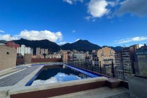 波哥大Apartaestudio en Chapinero muy bien ubicado的从带游泳池的建筑屋顶上欣赏美景