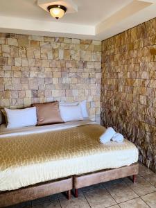 TarbacaHotel Colinas Altavista的砖墙房间的一个床位