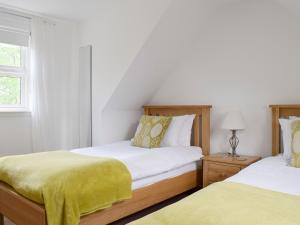 Kippen艾科恩小屋的一间卧室配有两张带黄床单的床