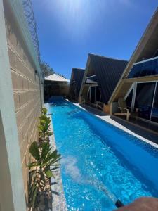 佩德纳莱斯Villa completa confotable para 9 personas的蓝色水屋旁的游泳池