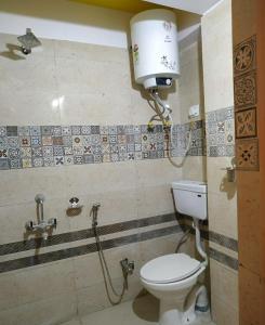大吉岭Rambler's Nesting Homestay的浴室配有卫生间和墙上的灯。
